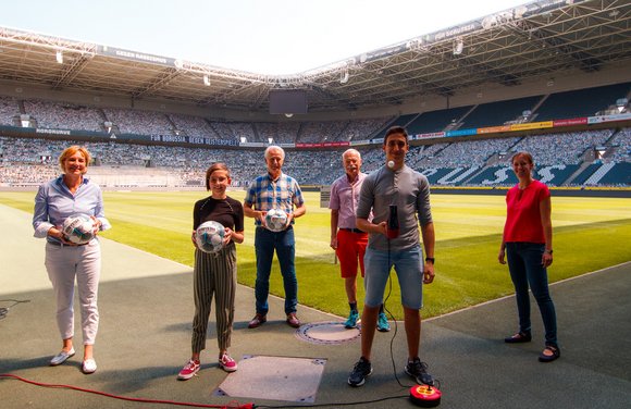Das Team der Junior Uni Wuppertal mit Rainer Bonhof im Stadion von Borussia Mönchengladbach.